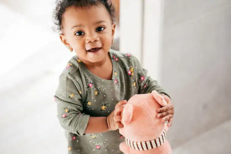Building brain connections toddler playing with plush pig toy, early childhood development, cognitive growth, sensory play, neural development.