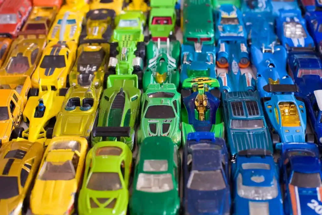 Yellow, green, and blue toy cars arranged in rows, illustrating creative play and learning opportunities for children.