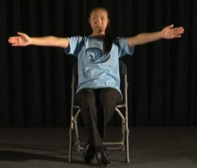 Reach for better brain development with seated arm stretch exercises.