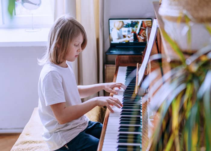 Piano-playing child stimulating brain connections, enhancing cognitive development and creativity.
